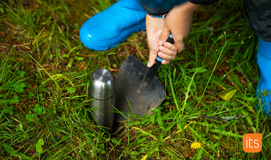 a child burying a drinking bottle